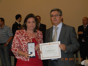 Montse recoge el premio de manos de Rafael, Director del centro